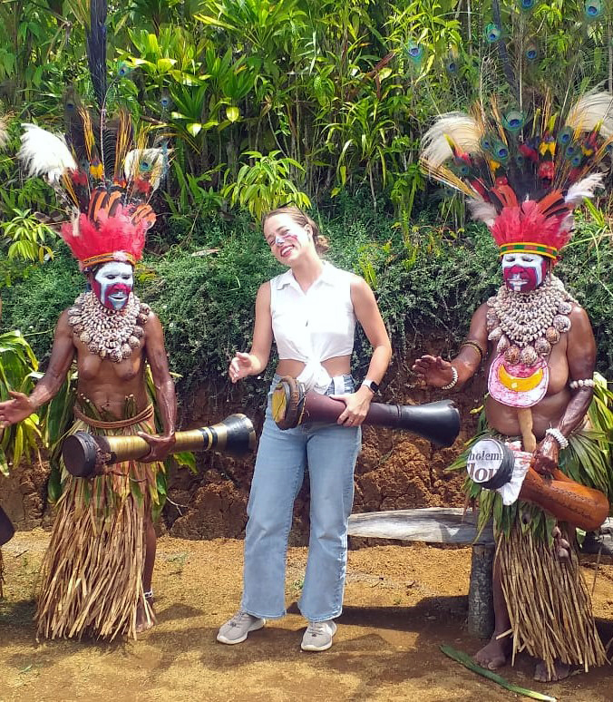 Tourist beating kundu drum with traditional women3